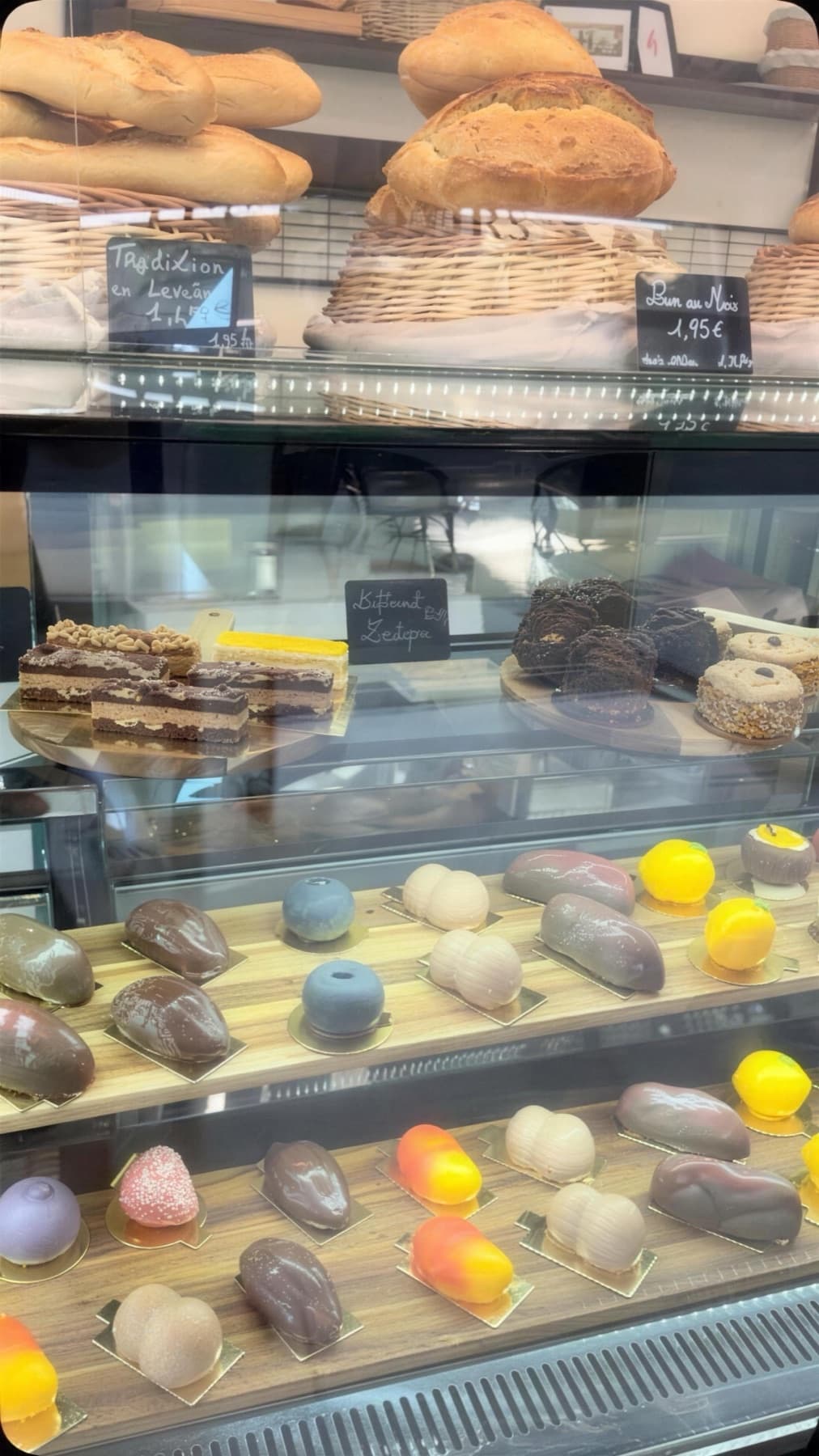 Les baguettes et les pains de campagne dans leurs paniers d’osier, au-dessus de la vitrine